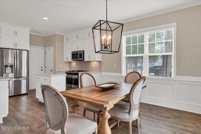 dining room with dark hardwood / wood-style flooring, crown molding, and a notable chandelier