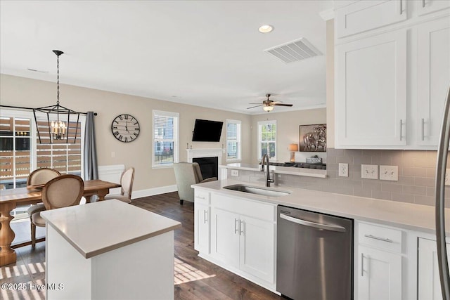 kitchen with ceiling fan with notable chandelier, sink, white cabinetry, and dishwasher