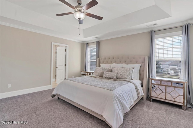 carpeted bedroom with ceiling fan, crown molding, and a tray ceiling