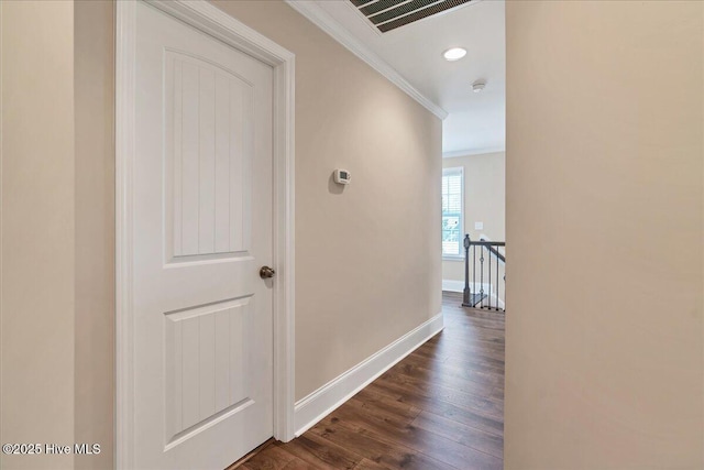 hallway with dark wood-type flooring and crown molding