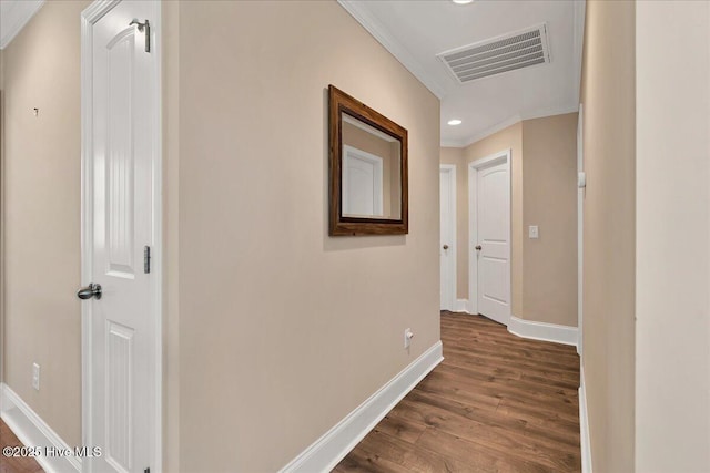 corridor with dark wood-type flooring and crown molding