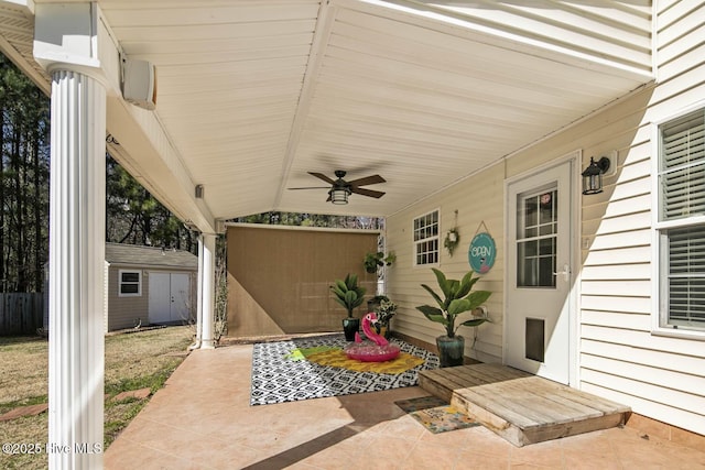 view of patio / terrace featuring a ceiling fan, an outdoor structure, fence, and a shed