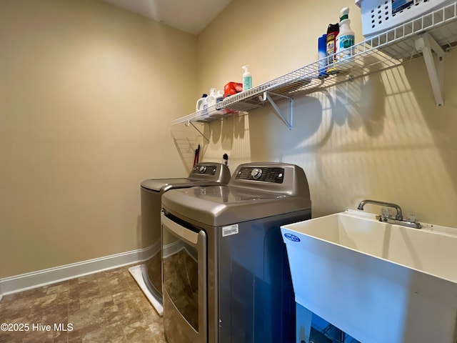 clothes washing area with sink and washer and clothes dryer