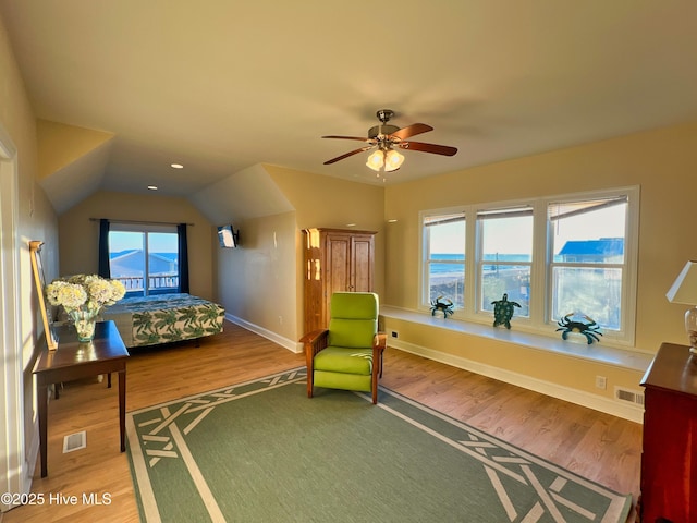 bedroom with ceiling fan, hardwood / wood-style floors, and multiple windows