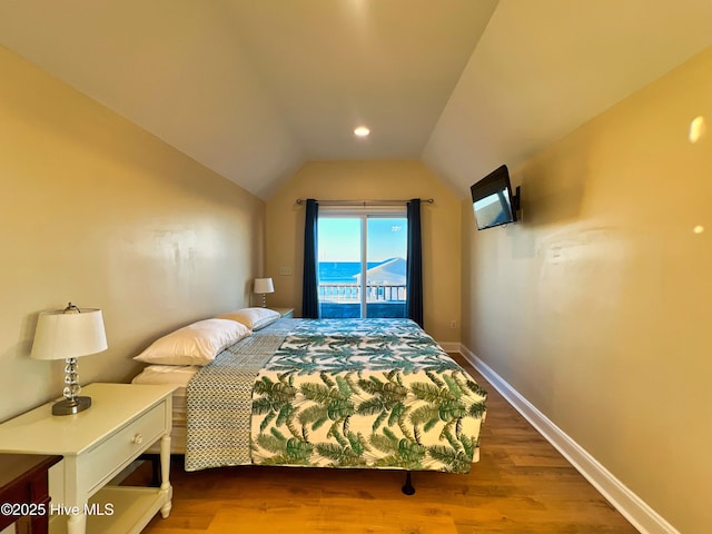 bedroom with access to outside, vaulted ceiling, and hardwood / wood-style flooring