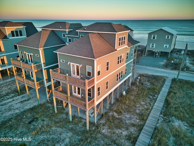 aerial view at dusk featuring a water view