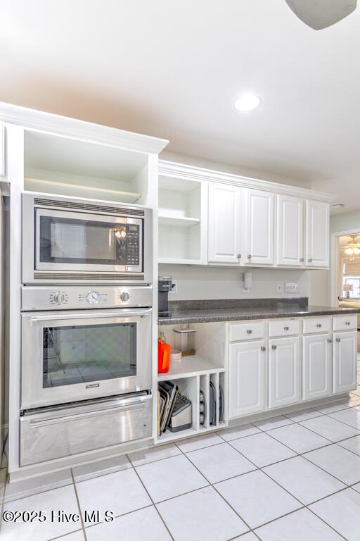 kitchen featuring white cabinetry, stainless steel appliances, and light tile patterned floors