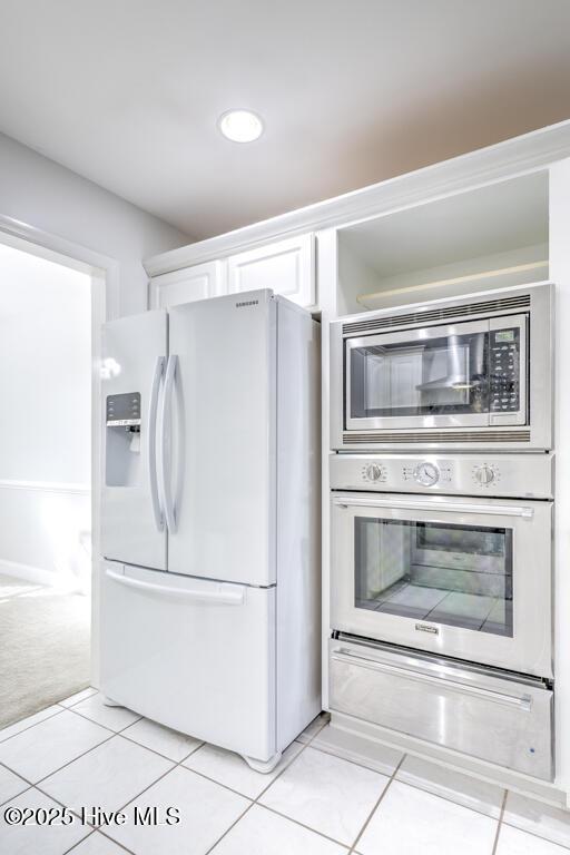 kitchen featuring white cabinets, light tile patterned floors, and appliances with stainless steel finishes