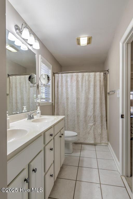 bathroom with tile patterned flooring, vanity, a shower with shower curtain, and toilet