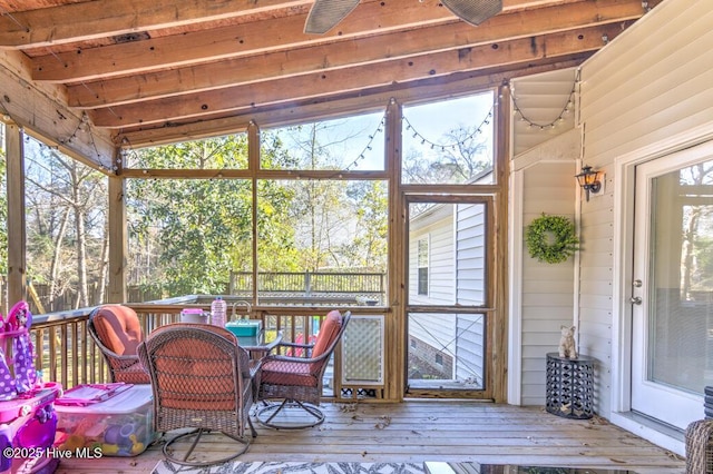 sunroom with lofted ceiling with beams and ceiling fan