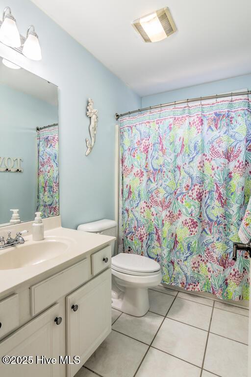 bathroom with tile patterned flooring, vanity, and toilet