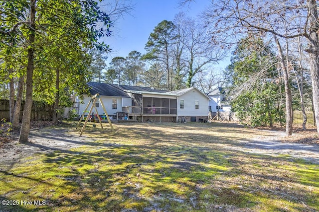 rear view of property with a lawn and a sunroom