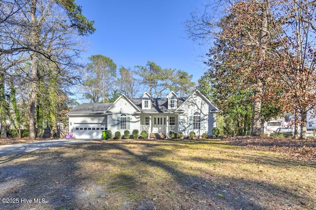 view of front of house featuring a front yard, a porch, and a garage