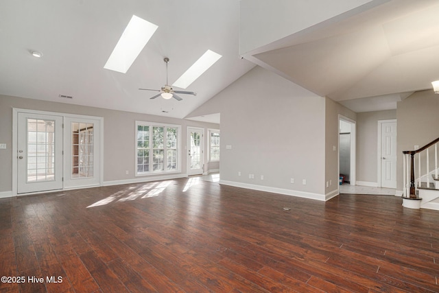 unfurnished living room featuring ceiling fan, dark hardwood / wood-style floors, high vaulted ceiling, and a skylight