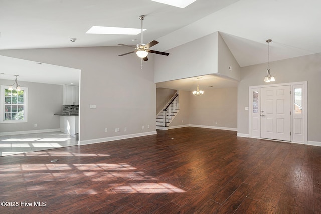 unfurnished living room featuring ceiling fan, dark hardwood / wood-style flooring, a skylight, and high vaulted ceiling