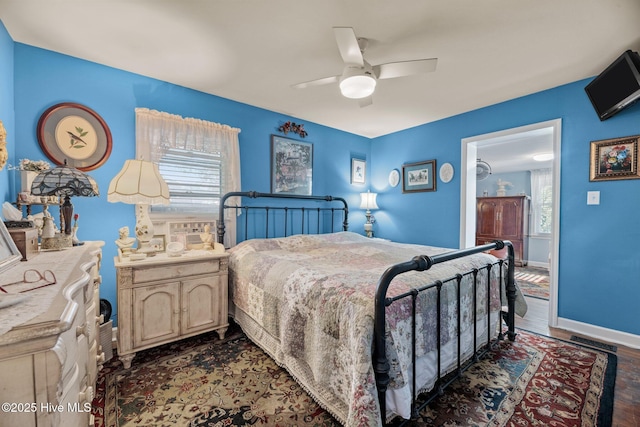 bedroom with multiple windows, dark hardwood / wood-style floors, and ceiling fan