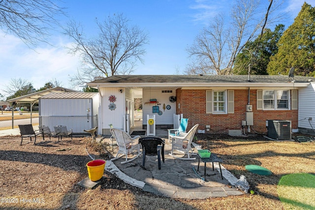 view of front of home featuring a fire pit, cooling unit, and a patio area