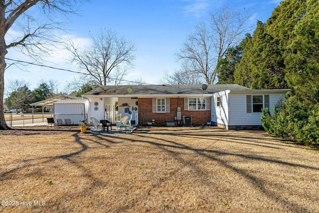 ranch-style house with a front yard, central AC, and a carport