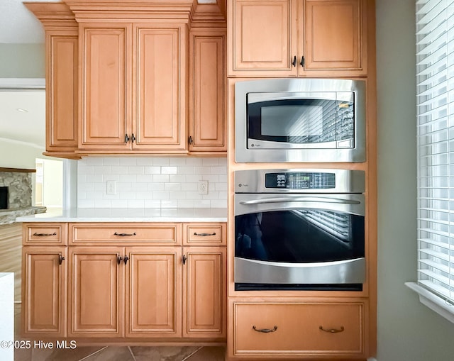 kitchen featuring backsplash, stainless steel appliances, a wealth of natural light, and tile patterned floors