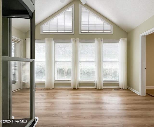 interior space featuring plenty of natural light, light wood-type flooring, and a textured ceiling