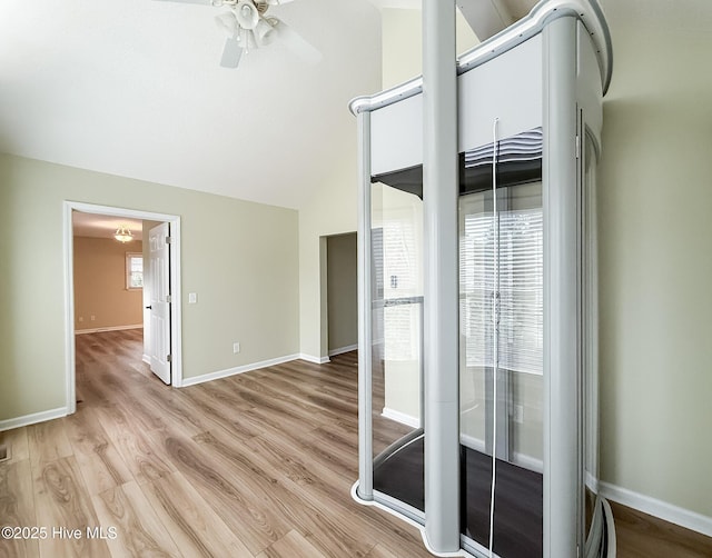 empty room with ceiling fan, light wood-type flooring, and lofted ceiling