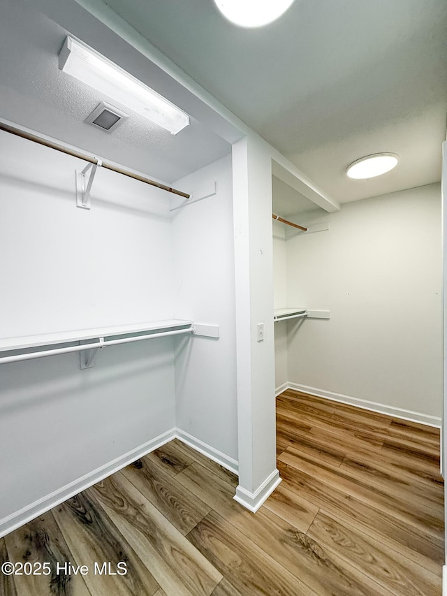 spacious closet with hardwood / wood-style floors