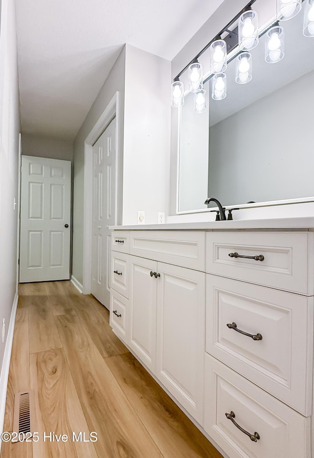 bathroom with vanity and wood-type flooring