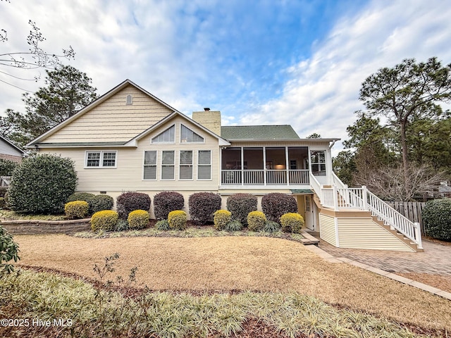 rear view of house featuring a sunroom