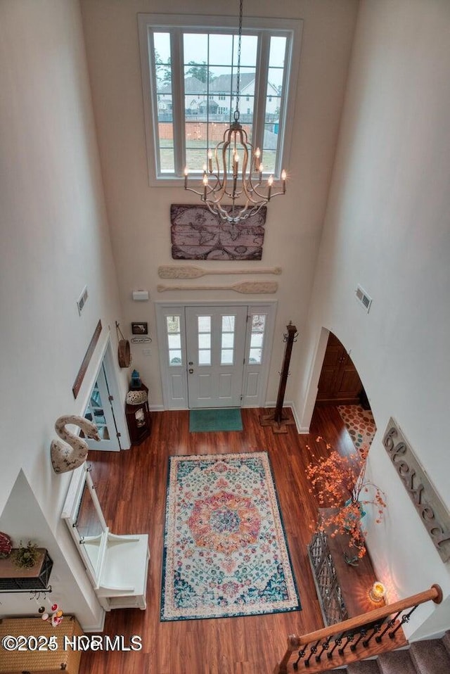 entrance foyer featuring hardwood / wood-style flooring, a high ceiling, and an inviting chandelier