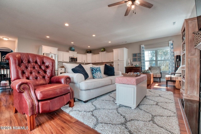 living room featuring ceiling fan and light hardwood / wood-style flooring