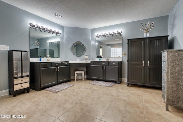 bathroom featuring tile patterned floors, vanity, and a textured ceiling