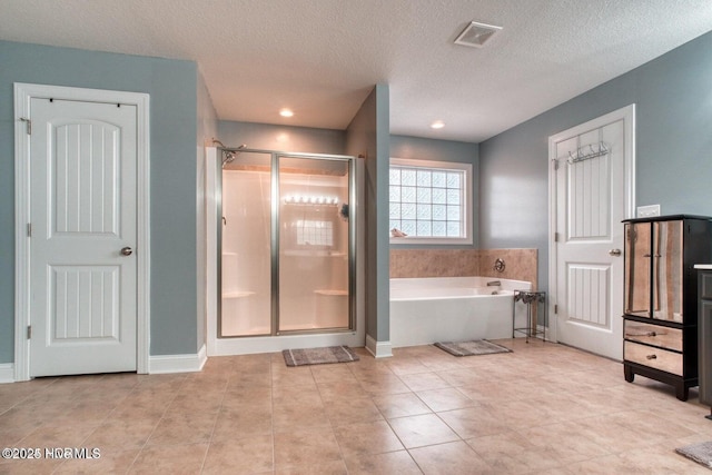 bathroom featuring tile patterned floors, a textured ceiling, and independent shower and bath