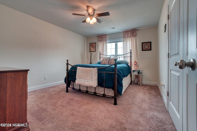 carpeted bedroom featuring a textured ceiling and ceiling fan