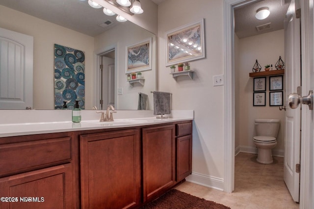 bathroom with vanity, toilet, and a textured ceiling