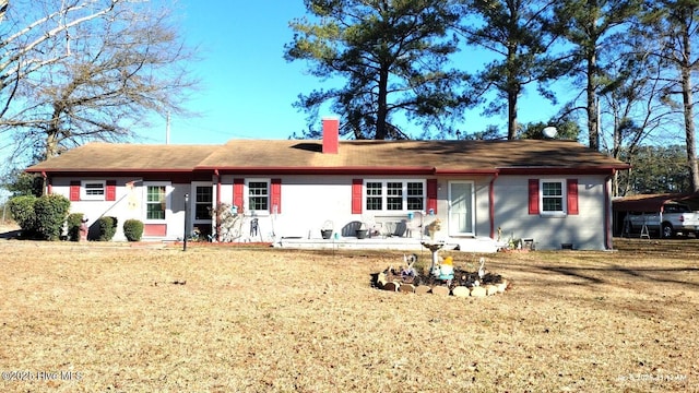 rear view of house featuring a lawn and a carport