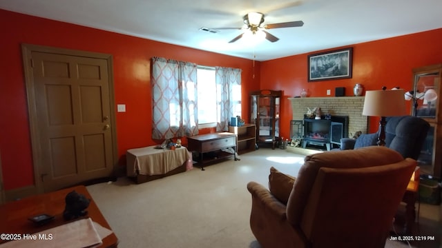 living room featuring carpet floors, a fireplace, and ceiling fan