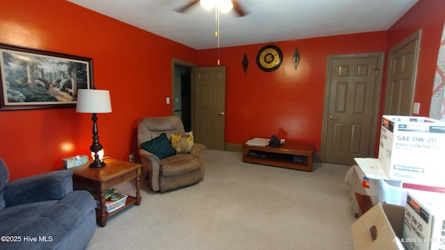 living area featuring carpet flooring and ceiling fan