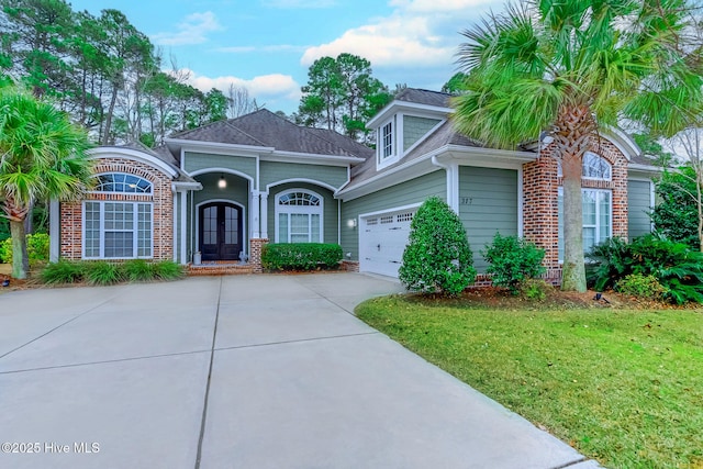 view of front of house with french doors, a front lawn, and a garage