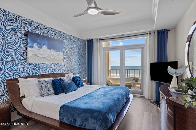 bedroom featuring wood finished floors, access to exterior, crown molding, and a ceiling fan
