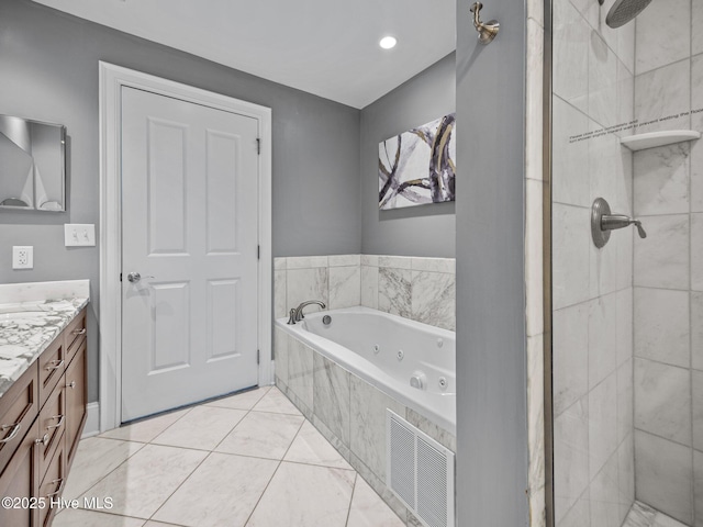bathroom with tile patterned flooring, visible vents, vanity, a tub with jets, and a stall shower