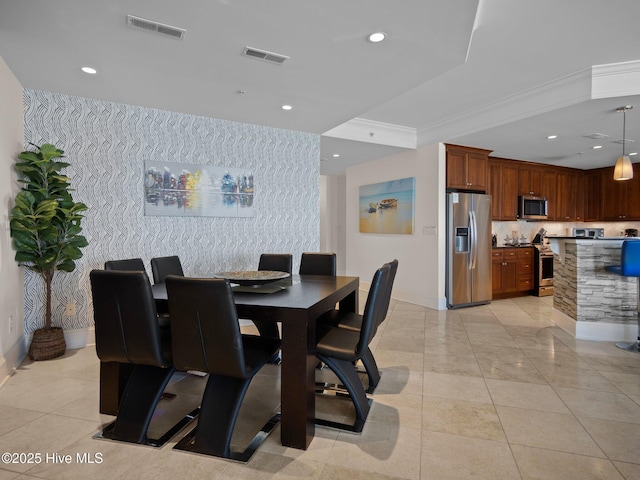 dining room with light tile patterned floors and ornamental molding