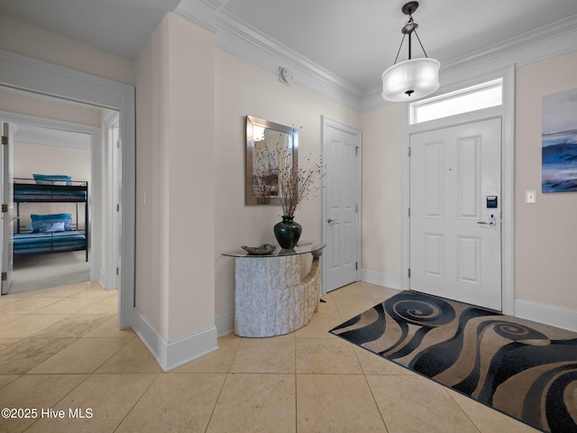 foyer entrance featuring light tile patterned flooring, crown molding, and baseboards