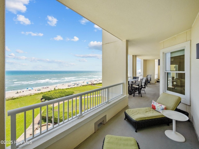 balcony featuring a water view and a beach view