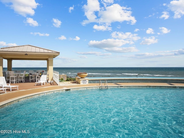 pool featuring a gazebo, a water view, and a patio