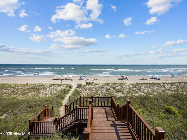 view of water feature with a beach view and stairway
