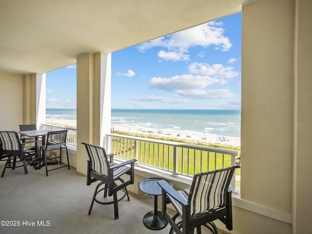 balcony featuring a water view and a beach view