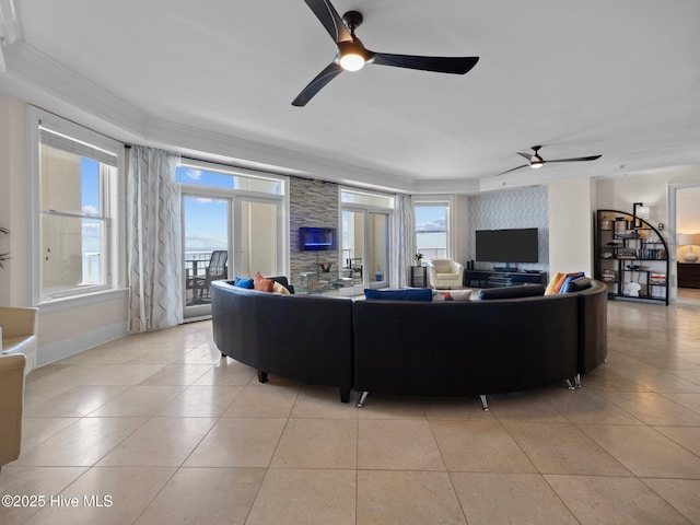 living area featuring a ceiling fan, baseboards, ornamental molding, and light tile patterned flooring