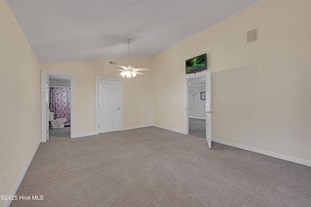 carpeted spare room featuring ceiling fan and lofted ceiling