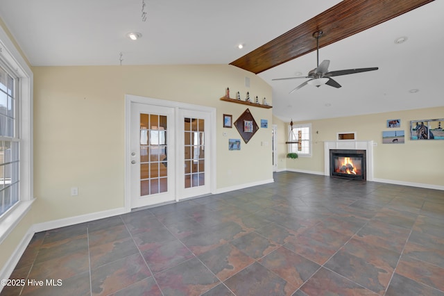 unfurnished living room with lofted ceiling with beams, ceiling fan, and french doors