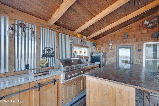 kitchen featuring light brown cabinets, vaulted ceiling with beams, stainless steel refrigerator, and a wealth of natural light